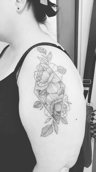 Floral fine line tattoo with an abstract twist on an arm.